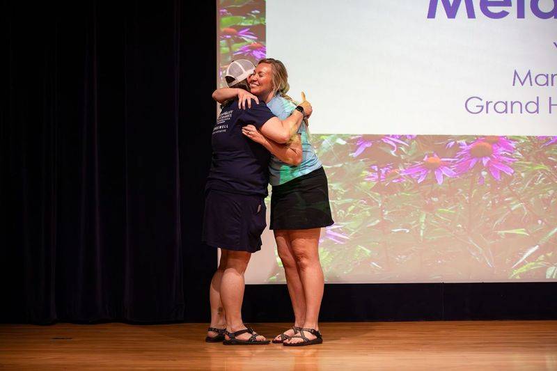 Groundswell staff standing with an educator smiling
